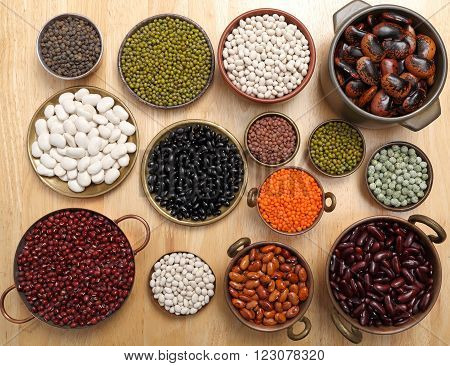 Beans peas and lentils in metal bowls.