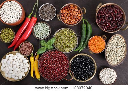 Beans peas and lentils in metal bowls.