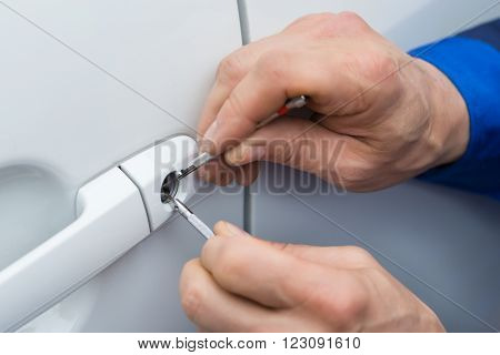 Hand Holding Lockpicker To Open Car Door