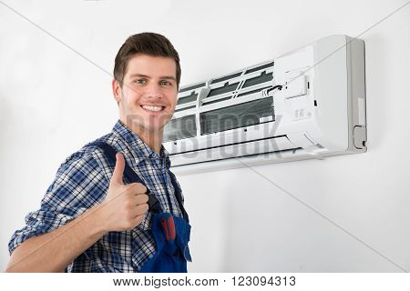 Young Happy Male Technician Gesturing Thumb Up