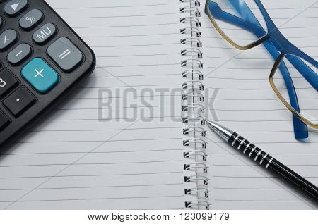 Calculator , black pen, glasses and book
