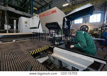 Saint-Petersburg Russia - March 23 2016: Worker young man miller is working by milling machine in working overalls shop engineering plant. The large milling machine.
