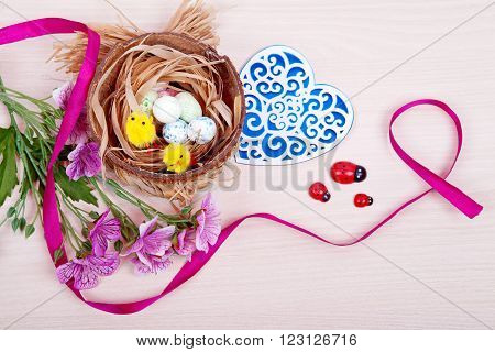 Nest with eggs and chicks on a wooden background. Easter