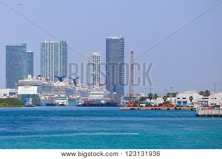MIAMI BEACH, USA - MAY 9, 2015: Several cruise ships at the Port of Miami with skyscrapers in the back.
