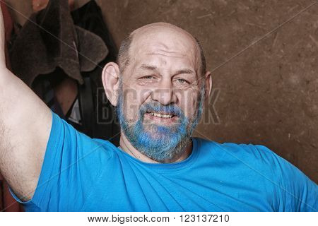 close-up portrait of an adult man with a blue beard and mustache in the dressing room
