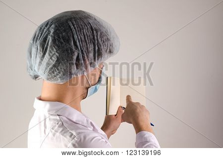 man doctor holding notepaper and show blanck page with finger on neutral background.