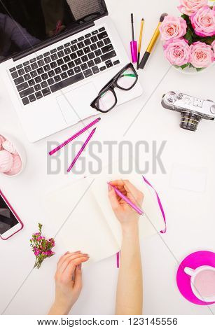 The female hands writing against fashion woman objects on white. Concept of female mockup and comfortable  female workplace