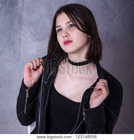 Teen Girl Posing In A Studio On A Dark Background In Leather Jacket