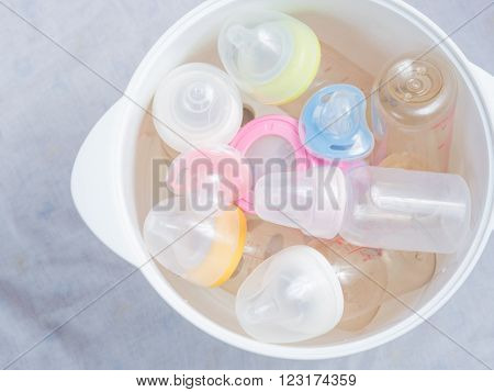 Nipple teethers and milk bottles in steam sterilizer and dryer. Steam sterilizer used for sterilize baby accessories by high temperature steam.