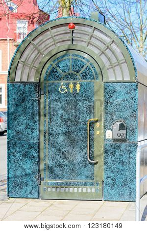 Kristianstad Sweden - March 20 2016: A public toilet free of charge as a service to strollers in the city. The door signs tell that it is for both sexes and that it is suited for disabled persons.