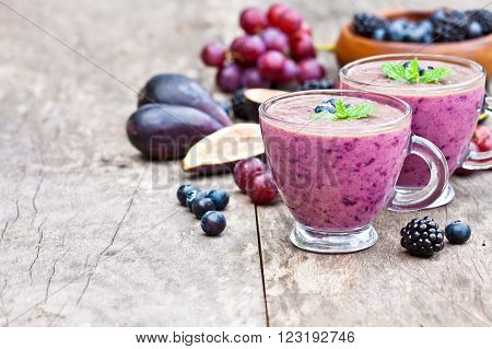 fresh healthy pulpy cocktail with purple fruits and berries