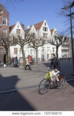 Amsterdam, Netherlands, 17 march 2016: young man on bicycle on spui square in centre of amsterdam on sunny winter day