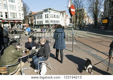 Amsterdam, Netherlands, 17 march 2016: men enjoy beer on Spui square on sunny day in centre of amsterdam