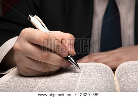man is looking for information in the dictionary close up