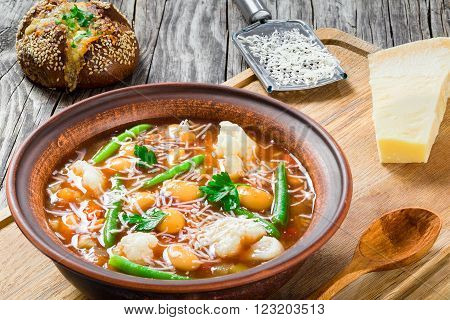 Minestrone vegetable soup with beans cauliflower tomatoes close-up top view