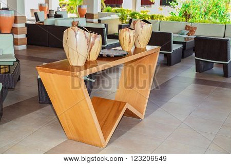 Cayo Coco island, Pestana, Cuba, Sep 2, 2015 nice modern stylish lobby bar interior with closeup view of natural wood stand table and gorgeous beautiful decorated vases