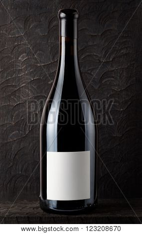 Bottle of Shiraz red wine, old wooden surface in background