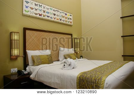 CLUB MAHINDRA RESORT, VIRAJPET, KARNATKA/INDIA MAR 13:  King sized bed in Club Mahindra resort studio accommodation decorated with beautiful puppy towel art and butter fly theme head board Mar 13, 2016 in Virajpet,Karnataka,India.
