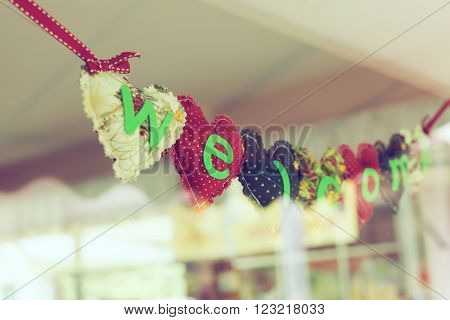 welcome message heart alphabet handmade hanging on mirror of decoration cafe coffee shop vintage style