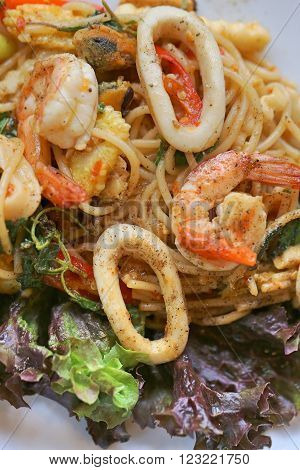 stir-fried spicy spaghetti with seafood. thai style stir-fried spicy spaghetti with seafood. stir-fried spicy pasta with seafood.