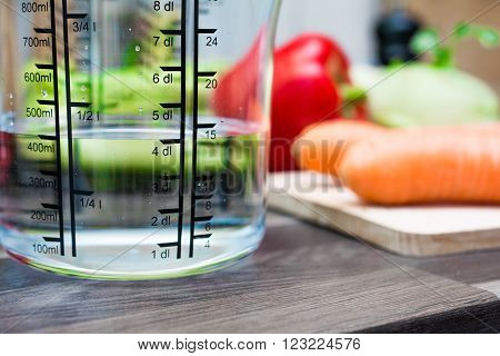 400Ml / 4Dl Of Water In A Measuring Cup On A Kitchen Counter With Vegetables
