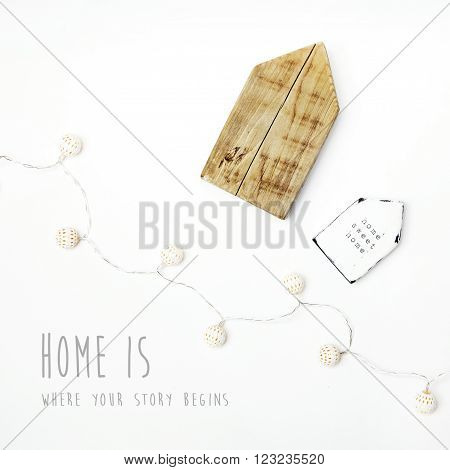Hipster scandinavian home interior decoration. Timy wooden houses with MOTIVATIONAL quote HOME IS WHERE YOUR STORY BEGINS.