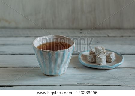 white ceramic cup with blue stripes cup of tea on a white background tea and Turkish delight pottery handmade