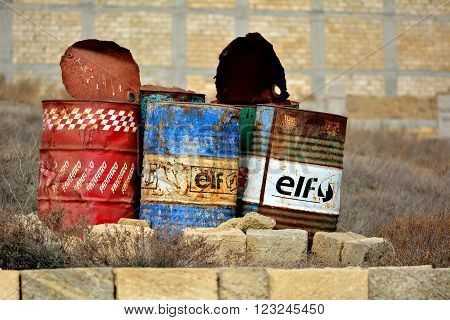 BAKU, AZERBAIJAN - FEBRUARY 10 2014 
Three old oil barrels outside of Baku, capital of Azerbaijan. Oil barrels stand discarded in a suburb of Baku, the capital city.  Evidence of the country's petrochemical industry is inescapable