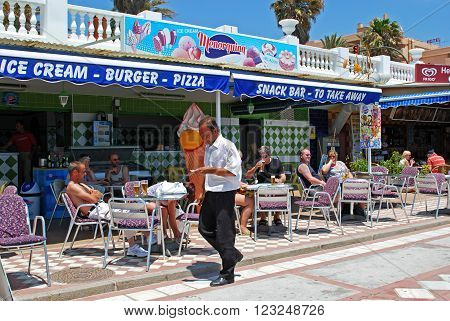 BENALMADENA, SPAIN - JUNE 2, 2008 - Tourists relaxing in pavement cafes on promenade Benalmadena Costa del Sol Malaga Province Andalusia Spain Western Europe, June 2, 2008.