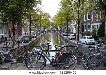AMSTERDAM; THE NETHERLANDS - AUGUST 18; 2015: View on beautiful street Oudezijds Achterburgwal, street life, canal and tourists. Amsterdam is capital of the Netherlands on August 18; 2015.