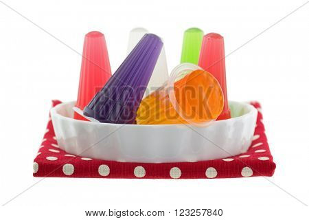 A bowl of colorful assorted carrageenan Jelly with fruity flavors in small plastic cones, isolated on white background