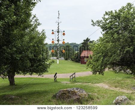Maypole, midsummer celebrations in Aland Islands. Buildings in the background.