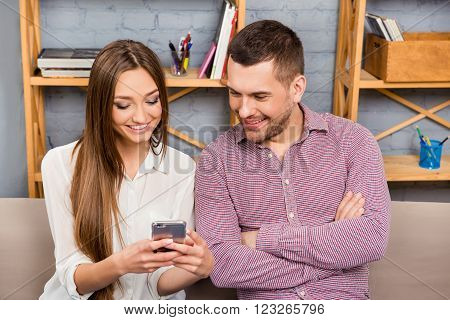 Pretty Girl Showing Mobile Phone To Her Husband