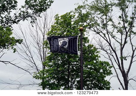 ELWOOD, ILLINOIS / UNITED STATES - MAY 30, 2015: A black POW/MIA Flag flies at the Abraham Lincoln National Cemetery in Elwood, Illinois.