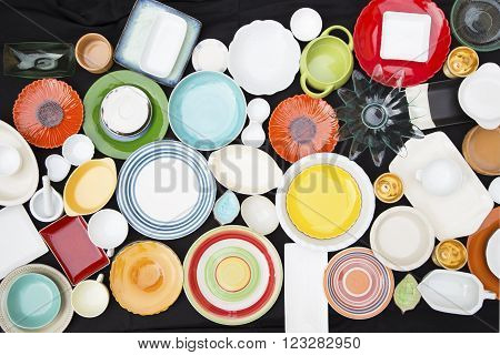 Colorful dishes and utensils on a black background