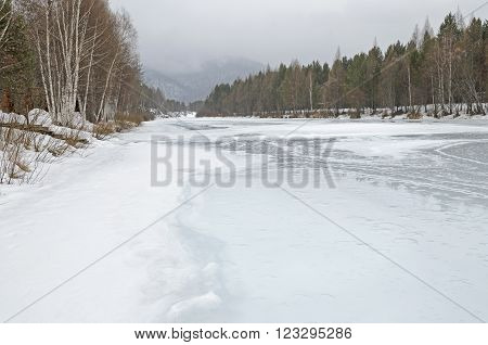 Irkutsk Region, Russia -March,20 2016: Icebound river on a cloudy spring day in the village. Kochergat Irkutsk Region Russia