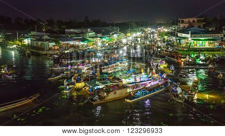 Soc Trang, Vietnam - February 3rd, 2016: Landscape purchases Floating Market at night with bustling boats crossing river in roundabout sales agricultural products  prepare to welcome Lunar New Year in Soc Trang, Vietnam