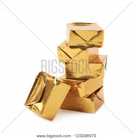 Stack of mulitple bouillon stock broth cubes wrapped in golden foil, composition isolated over the white background