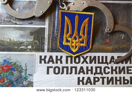 Kiev,Ukraine.FEB 20.ILLUSTRATIVE EDITORIAL.Chevron Ukrainian nazionalist battalion.Background - newspaper about West Frisian stolen art . February 20,2016 in Kiev, Ukraine