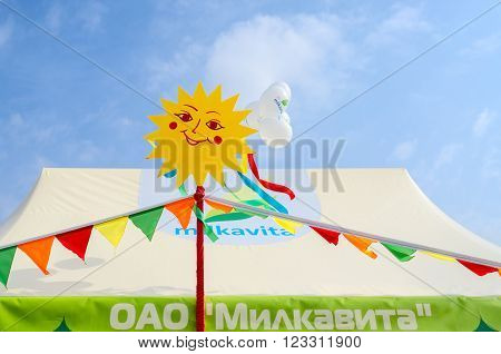 GOMEL BELARUS - MARCH 12 2016: Market stalls of open joint stock company "Milkavita" on Shrovetide festivities against the blue sky