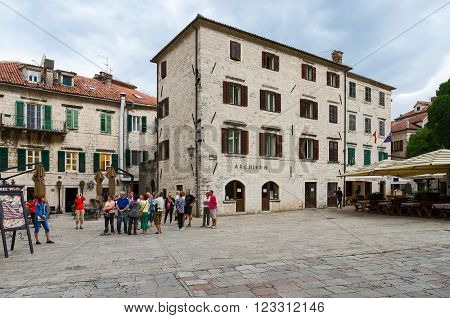 KOTOR MONTENEGRO - SEPTEMBER 21 2015: Unidentified tourists are near the Archive building on St. Tryphon Square Old Town Kotor Montenegro
