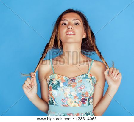 young pretty adorable woman close up like doll posing, natural makeup emotional gesturing on blue background