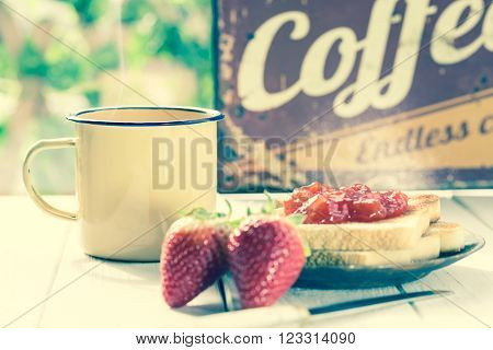 Coffee with milk and toast with strawberry jam
** Note: Shallow depth of field