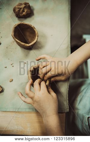 children's hands sculpts clay crafts pottery school