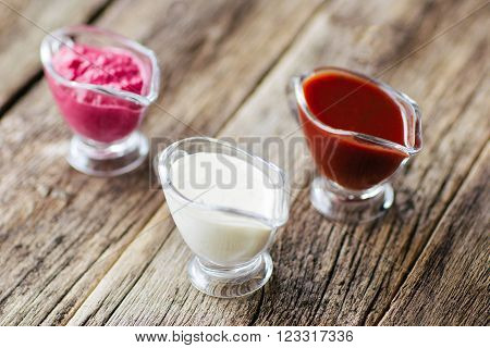 several sauces  of European cuisine. Several sauces : mayonnaise, ketchup, horseradish.  Top view on european cuisine  food on wooden background.