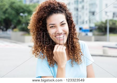 Beautiful mexican girl outdoor in the city with streets and buildings in the background