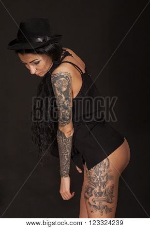 Beautiful sexy glamorous girl with tattoos on black background