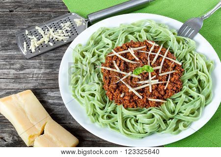 Bolognese ragout with green pasta tagliatelle top view