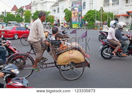 YOGYAKARTA - AUGUST 03: Traditional rikshaw transport on streets of Yogyakarta, Java, Indonesia on August 03, 2010. Bicycle rikshaw remains popular means of transport in many Indonesian cities.