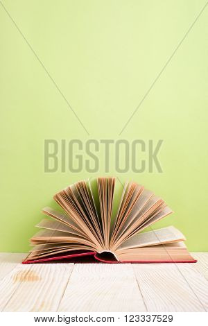 Open book on green wooden bavkground. Education background